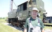 A photo of Ken Jones in front of a locomotive originally from the former Yugoslavia.
