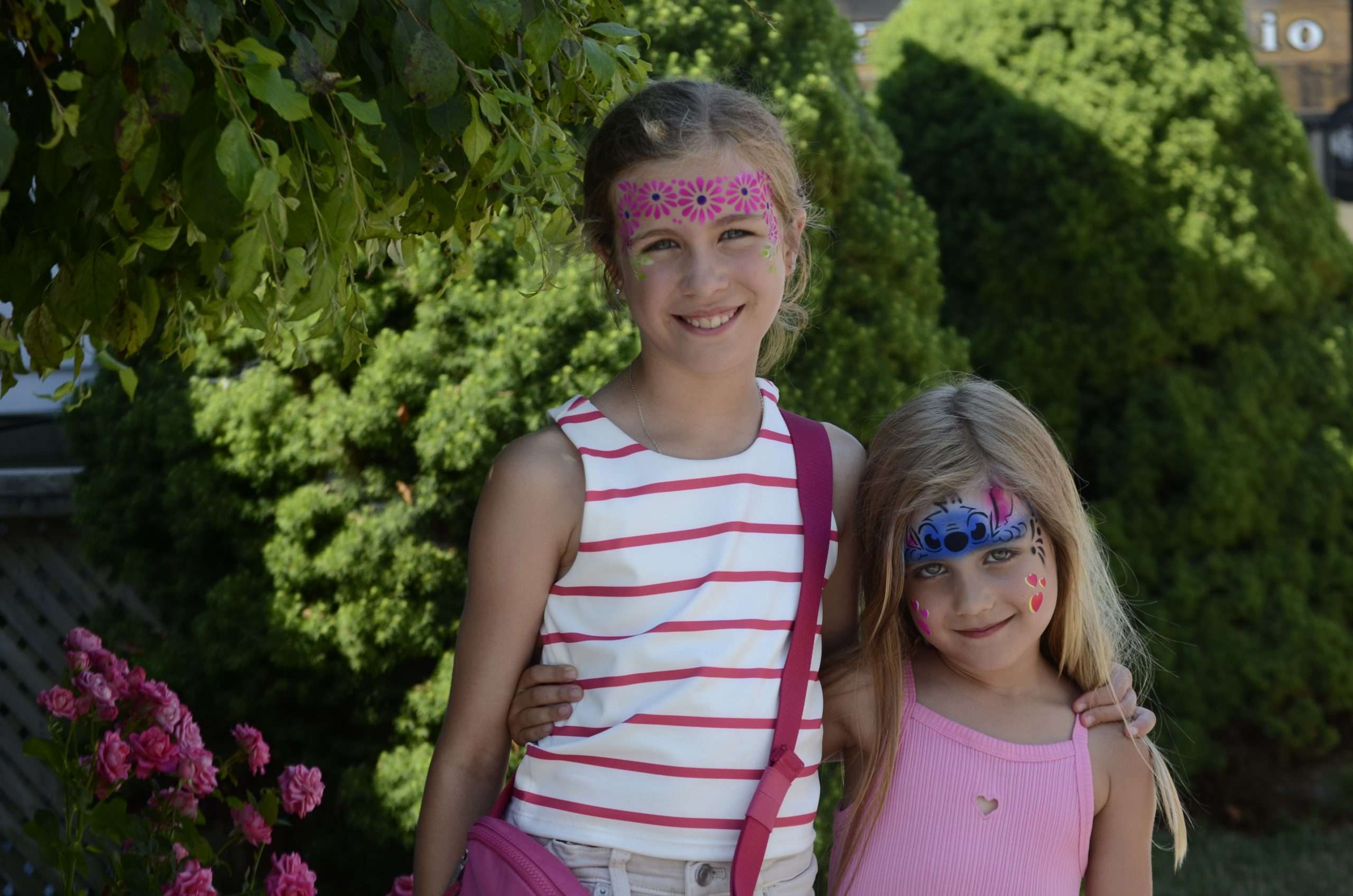 A photo of two young girls who just had their faces painted at Ridgefest