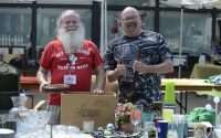Two volunteers from the Beachcombers Seniors Centre in front of the vendor table