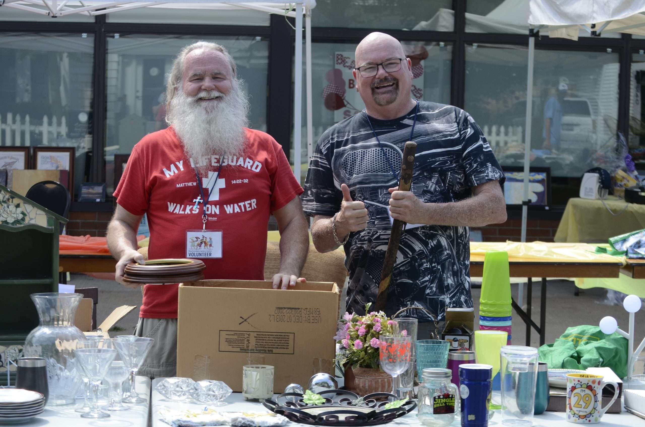 Two volunteers from the Beachcombers Seniors Centre in front of the vendor table