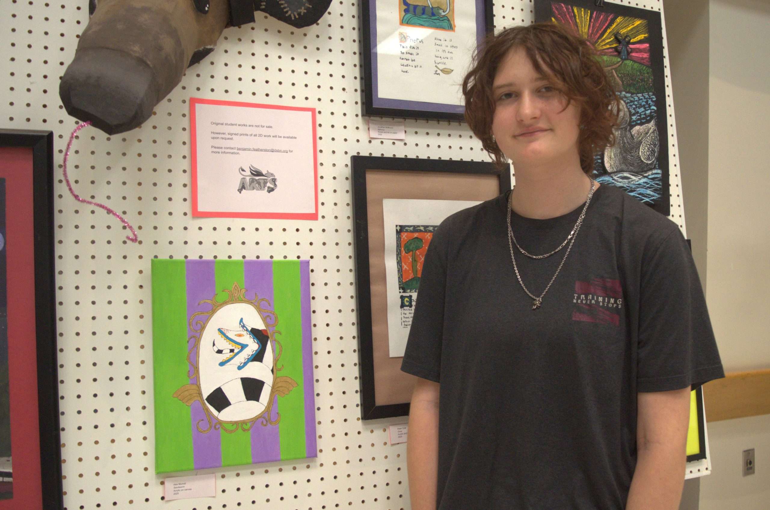 Artist standing in front of their artwork