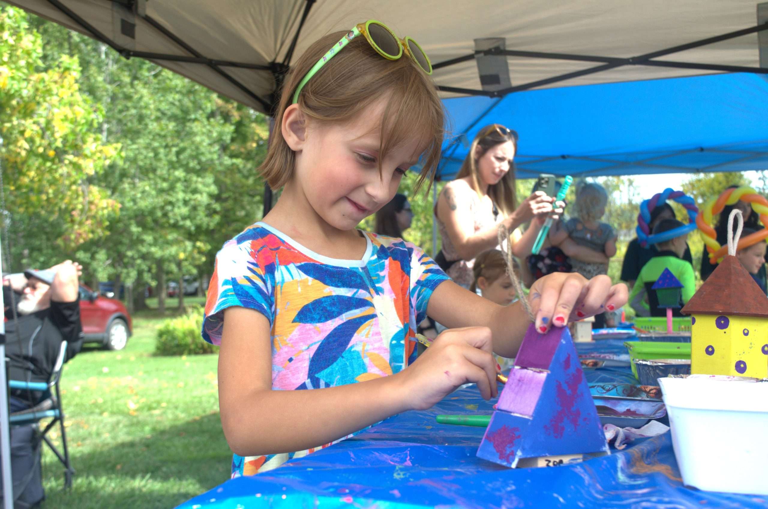 Girl painting a birdhouse